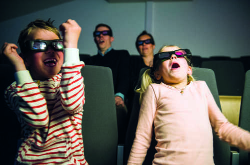 To barn og voksne med 3D briller som skvetter.