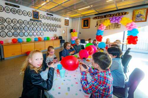 Bursdagselskap med barn rundt pyntet bord