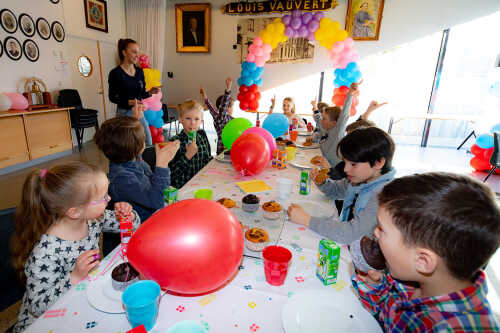 Bursdagselskap med barn rundt pyntet bord