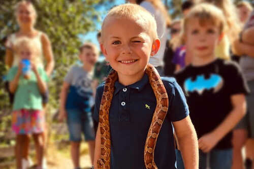 Blid gutt med slange rundt halsen.
