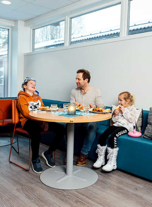 Far og to barn spiser frokost.