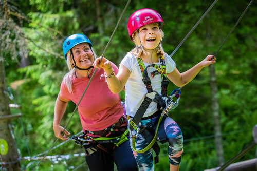 Bilde av jente med rosa hjelp og mor som klatrer.