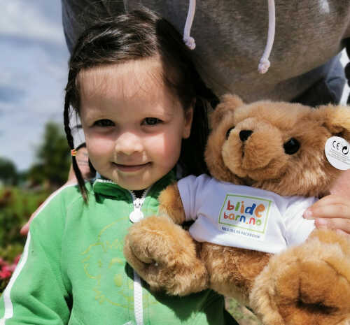 Liten jente med fletter som har vunnet Blidebarn-bamse.