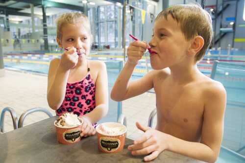 En jente og en gutt som koser seg med is.
